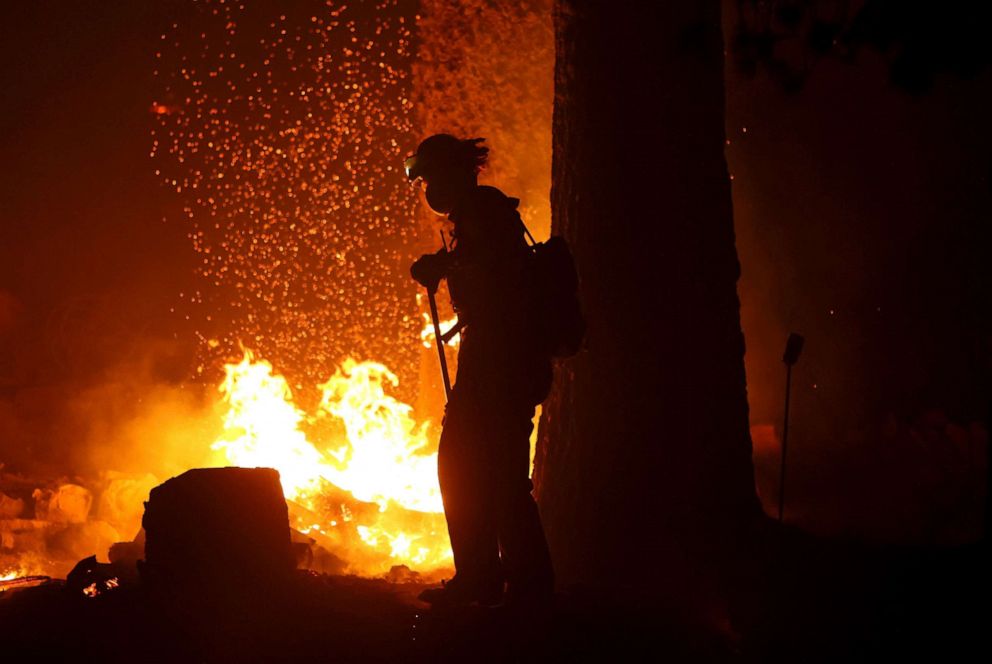 PHOTO: Firefighters extinguish hot spots as the Caldor Fire moves through the area on Aug. 30, 2021 near Twin Bridges, Calif. 