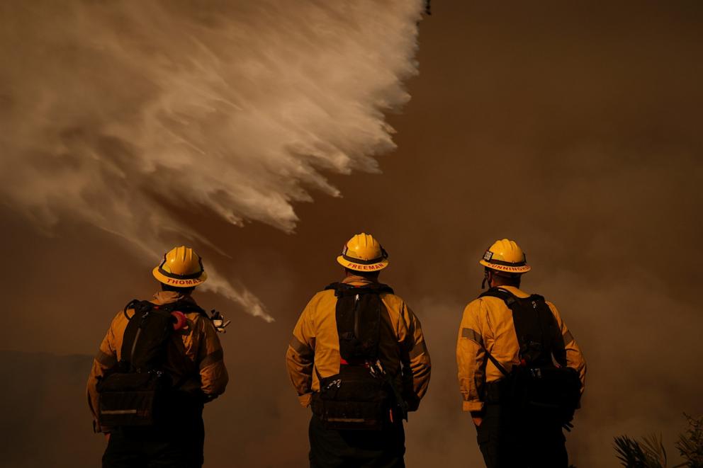 PHOTO: Firefighters watch water drops on the Palisades Fire in Mandeville Canyon, Jan. 11, 2025, in Los Angeles. 