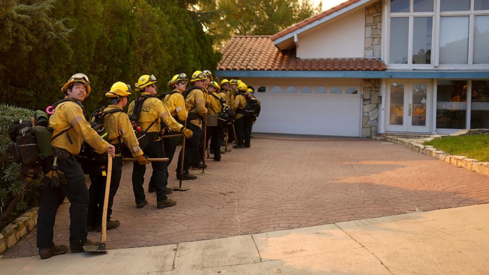 PHOTO: Firefighters line up for structure protection while battling the Palisades Fire in Mandeville Canyon, Jan. 11, 2025, in Los Angeles.