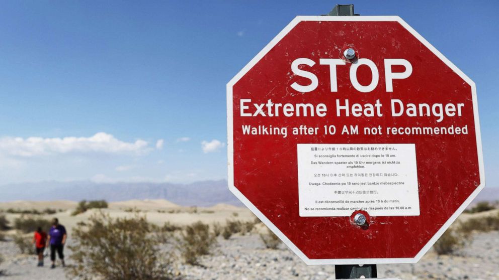 PHOTO: Visitors walk near a sign warning of extreme heat danger in Death Valley National Park, Calif., on Aug. 17, 2020. The temperature in the park reached 130 degrees on Aug. 16, one of the highest temperatures ever recorded.