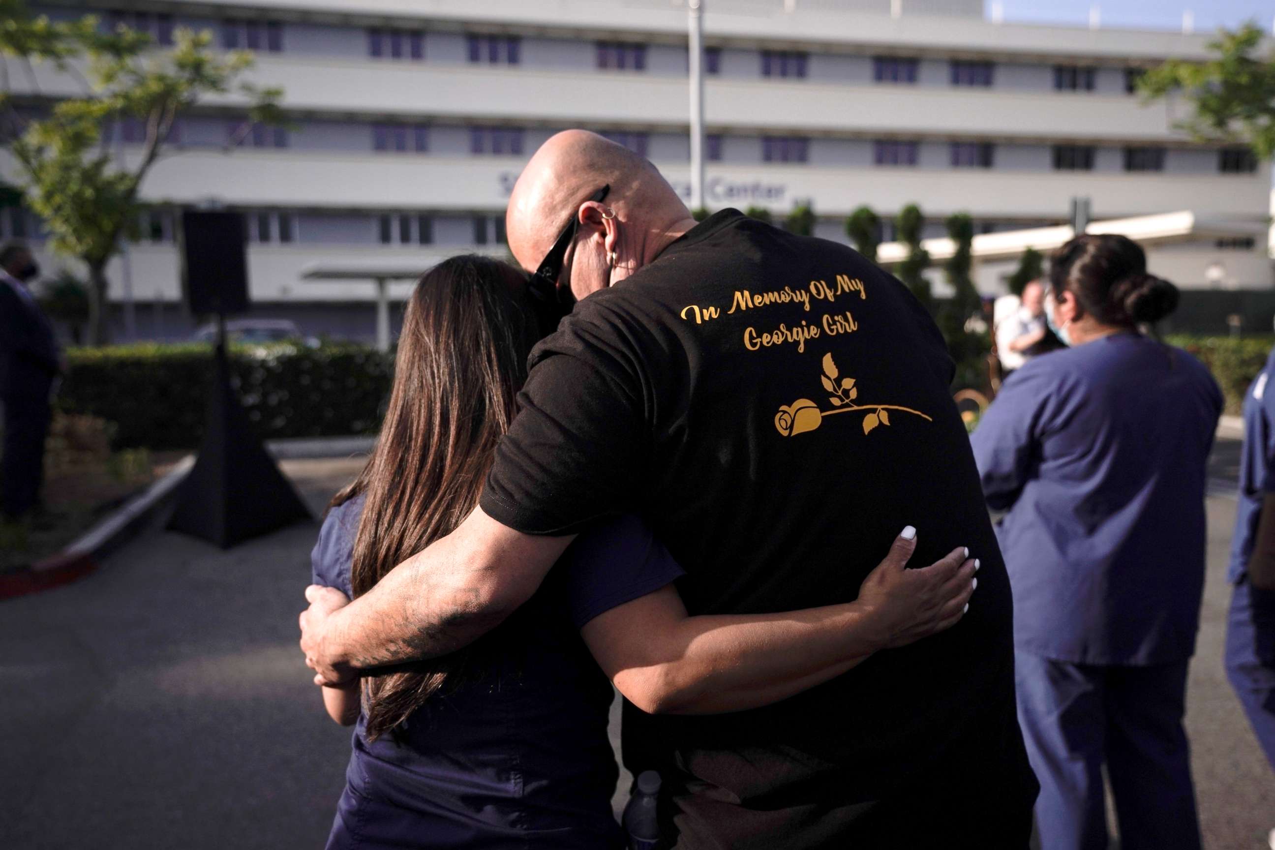 PHOTO: Rick Moran, right, who lost his wife to COVID-19 last year, is comforted at an event held to honor health care workers and those who lost loved ones to the virus at Providence St. Jude Medical Center in Fullerton, Calif., May 10, 2021.