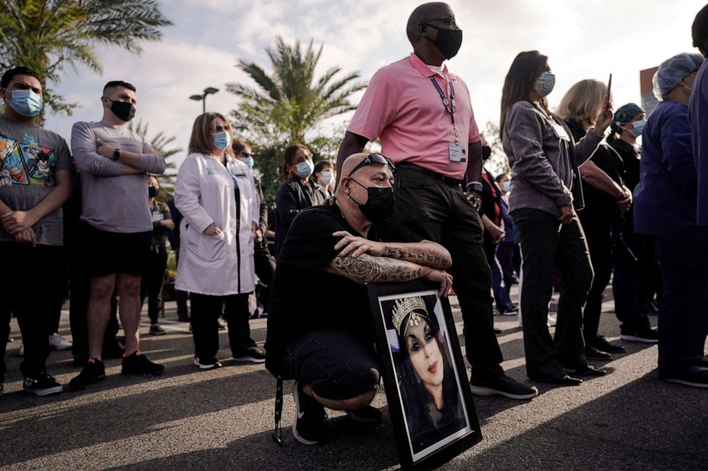 PHOTO: Rick Moran, kneeling, who lost his wife to COVID-19 last year, is comforted during an event held to honor health care workers and those who lost loved ones to the virus at Providence St. Jude Medical Center in Fullerton, Calif., May 10, 2021.