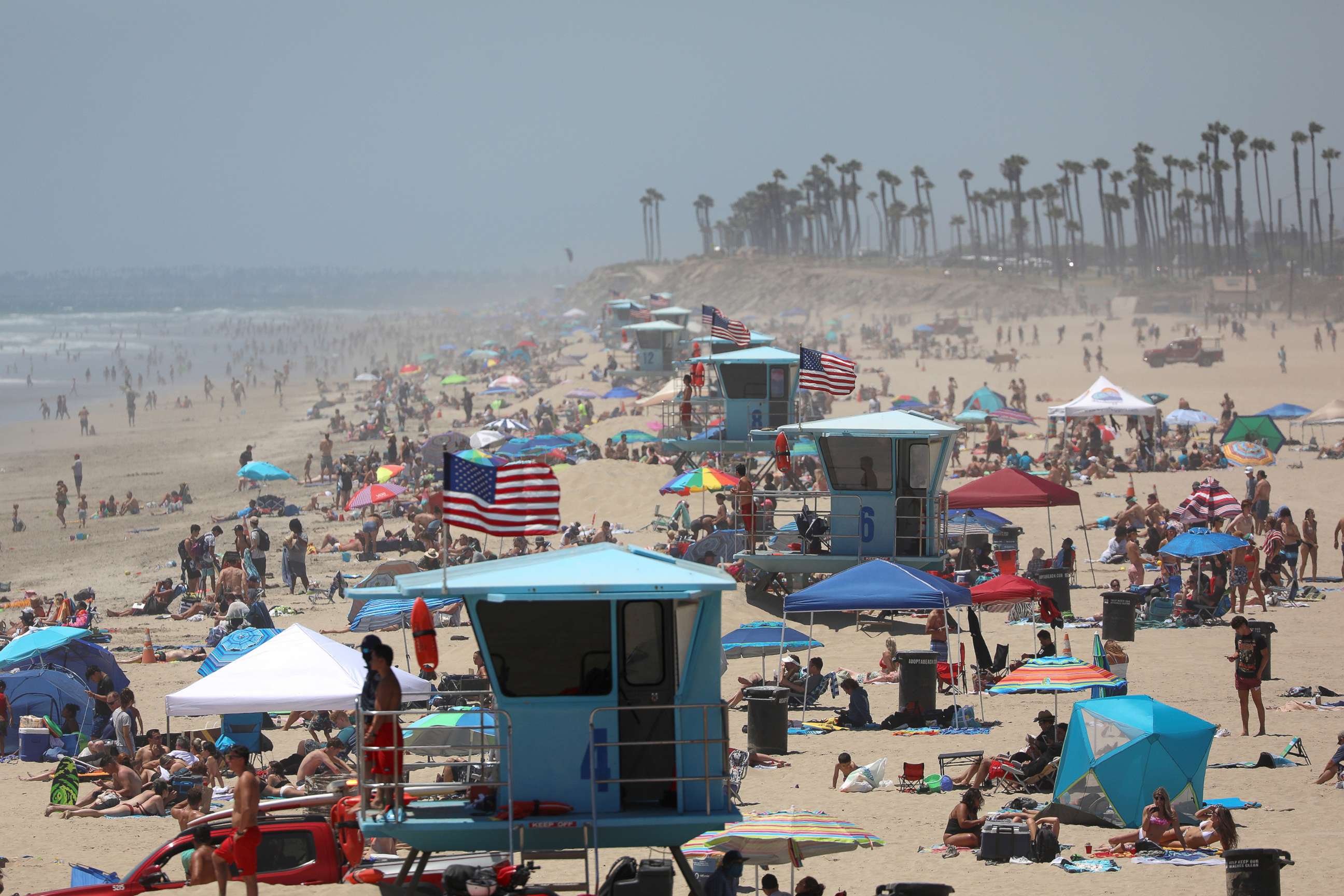 PHOTO: People gather at the beach on July 3, 2020 in Huntington Beach, Calif.