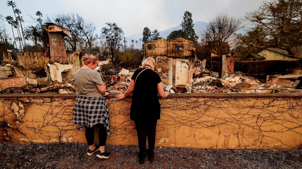 PHOTO: Hailey Ott and her mom Cindi Ott look at the damage caused to their home by the Eaton Fire, as powerful winds fueling devastating wildfires in the Los Angeles area force people to evacuate, in Altadena, Calif., Jan. 9, 2025. 