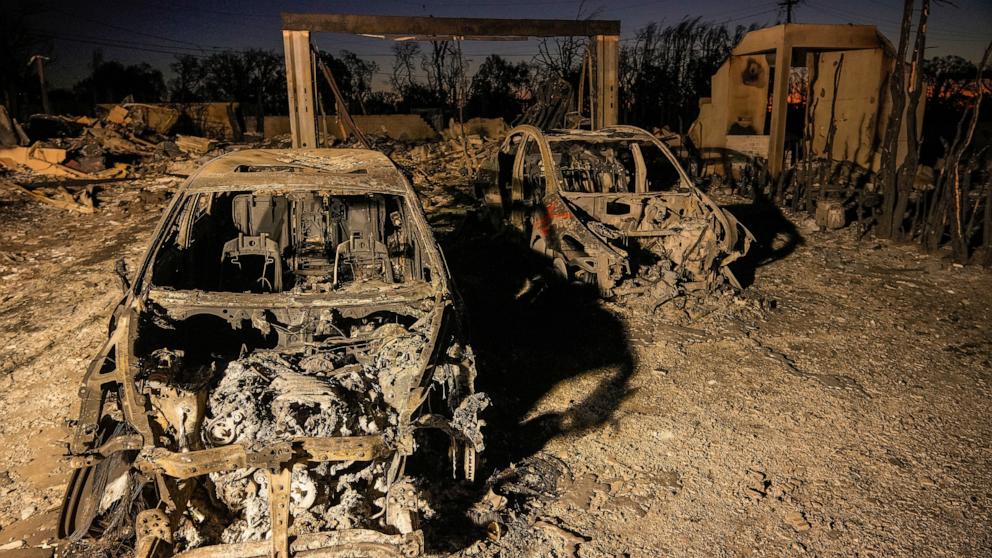 PHOTO: Charred vehicles are illuminated by utility lights at homes destroyed by the Palisades Fire in the Pacific Palisades neighborhood of Los Angeles, Jan. 16, 2025.
