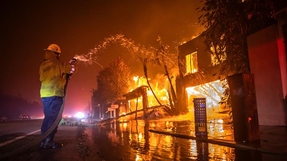 PHOTO: A firefighter battles the Palisades Fire while it burns homes at Pacific Coast Highway amid a powerful windstorm on Jan. 8, 2025 in Los Angeles, Calif.