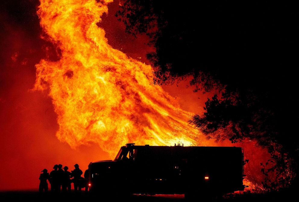 PHOTO: Butte county firefighters watch as flames tower over their truck at the Bear fire in Oroville, Calif., on Sept. 9, 2020.