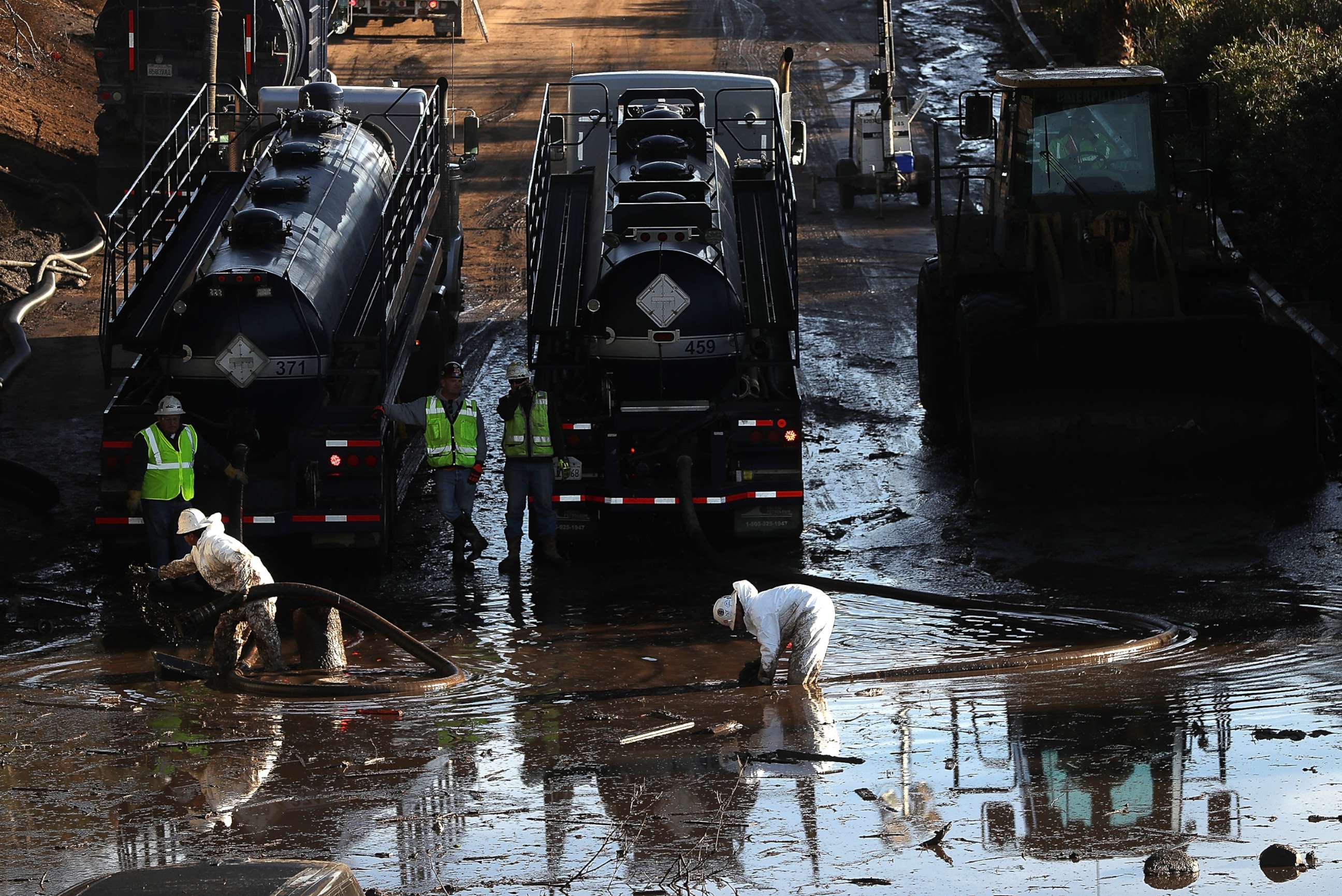 PHOTO: Workers attempt to drain a section of Highway 101 that was flooded following a mudslide on Jan. 12, 2018 in Montecito, Calif. 