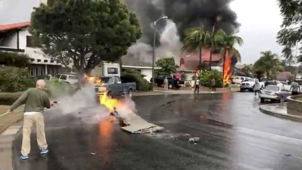 PHOTO: A man puts out fire on a piece of debris from a plane that crashed into a house in a residential neighborhood in Yorba Linda, Calif., Feb. 3, 2019.