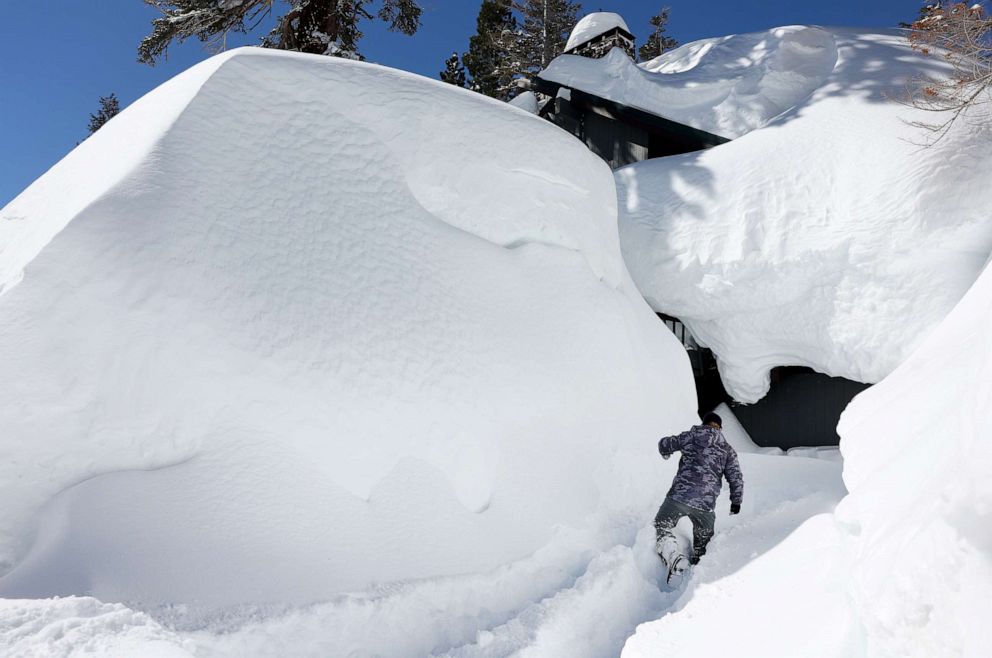 PHOTO: Jeff Wright checks on his neighbors home in the Sierra Nevada mountains, as snow piled up from new and past storms, March 29, 2023, in Mammoth Lakes, Calif.