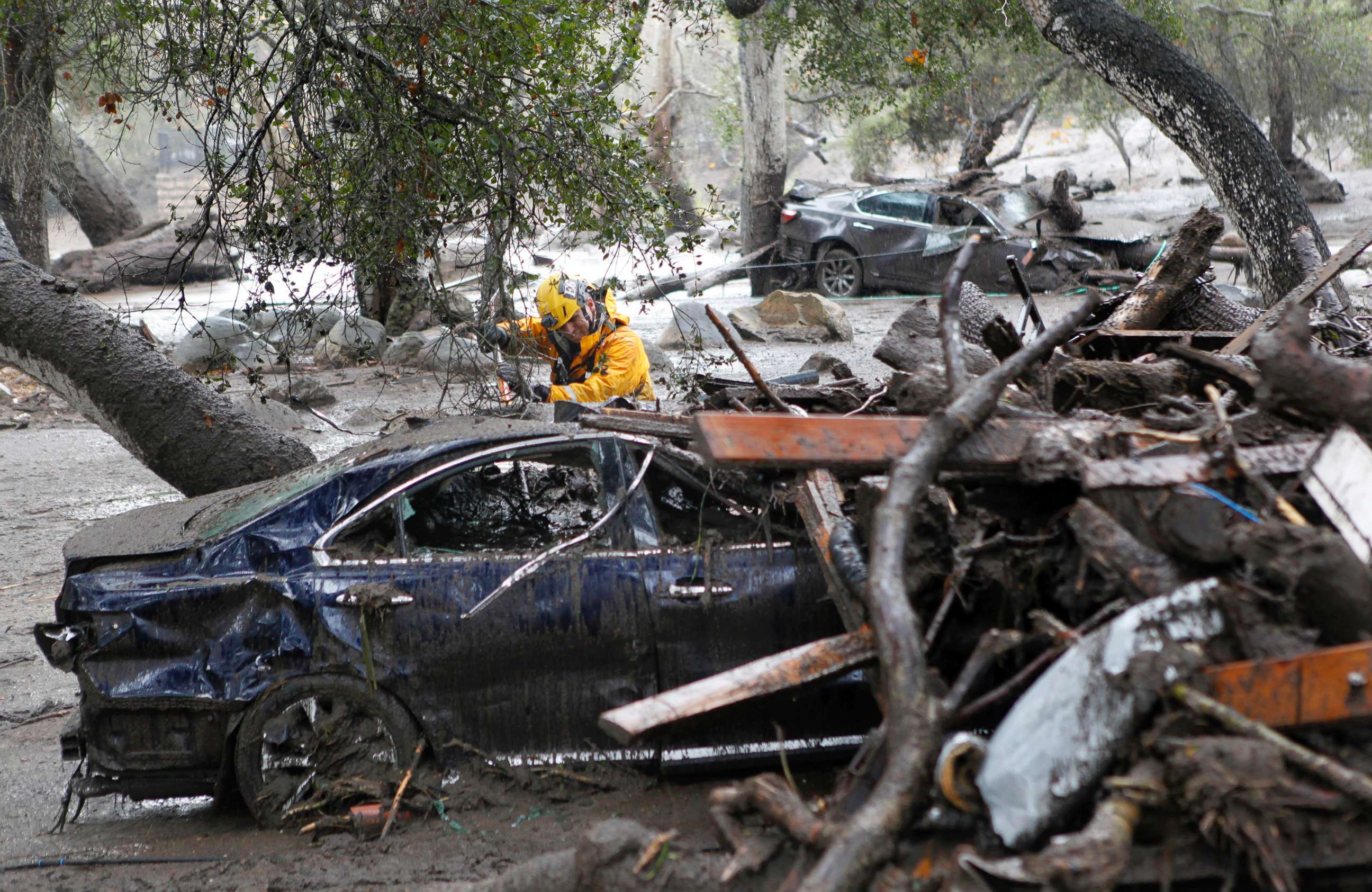 PHOTO: A member of the Long Beach Search and Rescue team looks for survivors in a car in Montecito, Calif., Jan. 9, 2018.