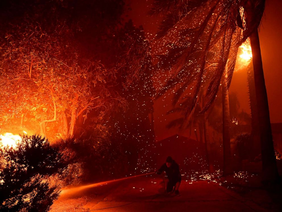 PHOTO: Randy Butler tries to protect his home as the Saddleridge Fire burns along Thunderbird Ave. in Porter Ranch, Calif., Oct. 11, 2019.