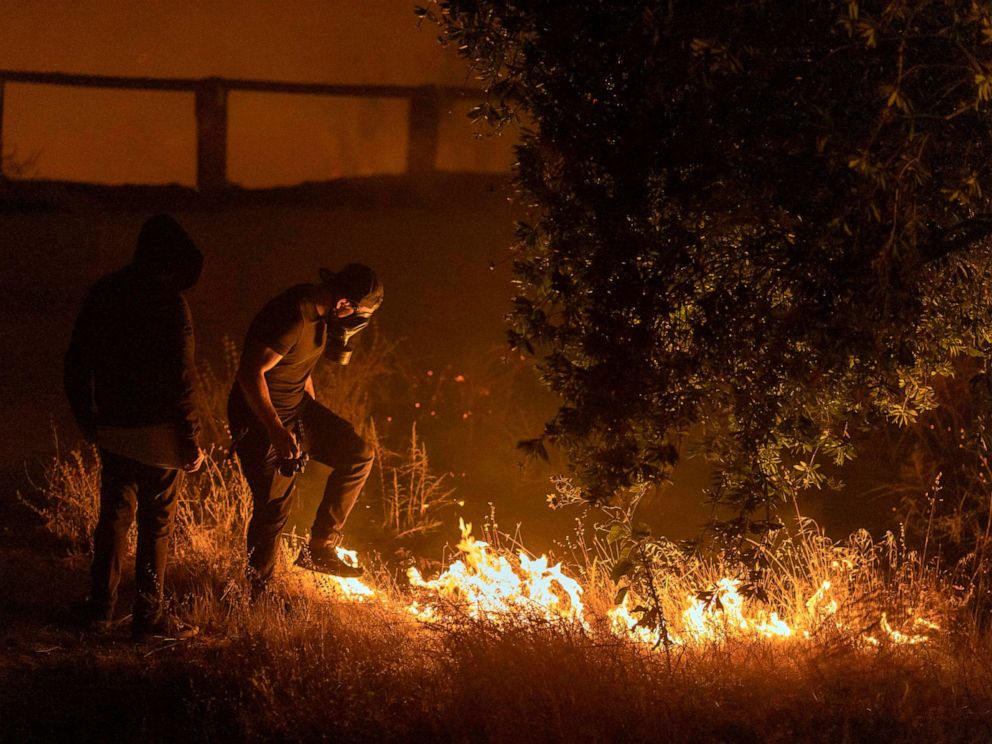 PHOTO: A man stomps on flames of the Saddleridge Fire in the Porter Ranch section of Los Angeles, in the early morning hours of Oct. 11, 2019.