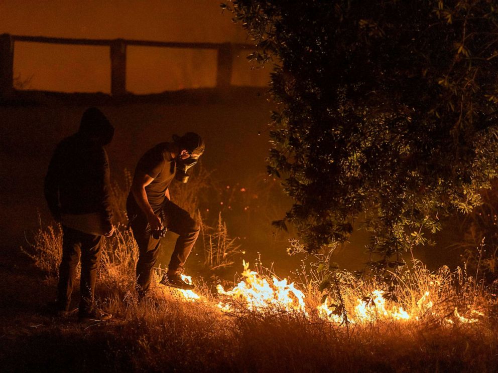 PHOTO: A man stomps on flames of the Saddleridge Fire in the Porter Ranch section of Los Angeles, in the early morning hours of Oct. 11, 2019.