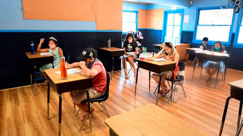 PHOTO: Children in an elementary school class wear masks and sit at desks spaced apart, per coronavirus guidelines, during summer school sessions at Happy Day School in Monterey Park, Calif., July 9, 2020.