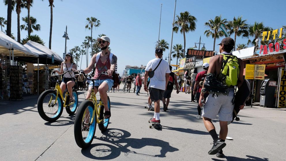 PHOTO: Cyclists ride along the Venice Beach boardwalk on May 25, 2020 in Venice, California.