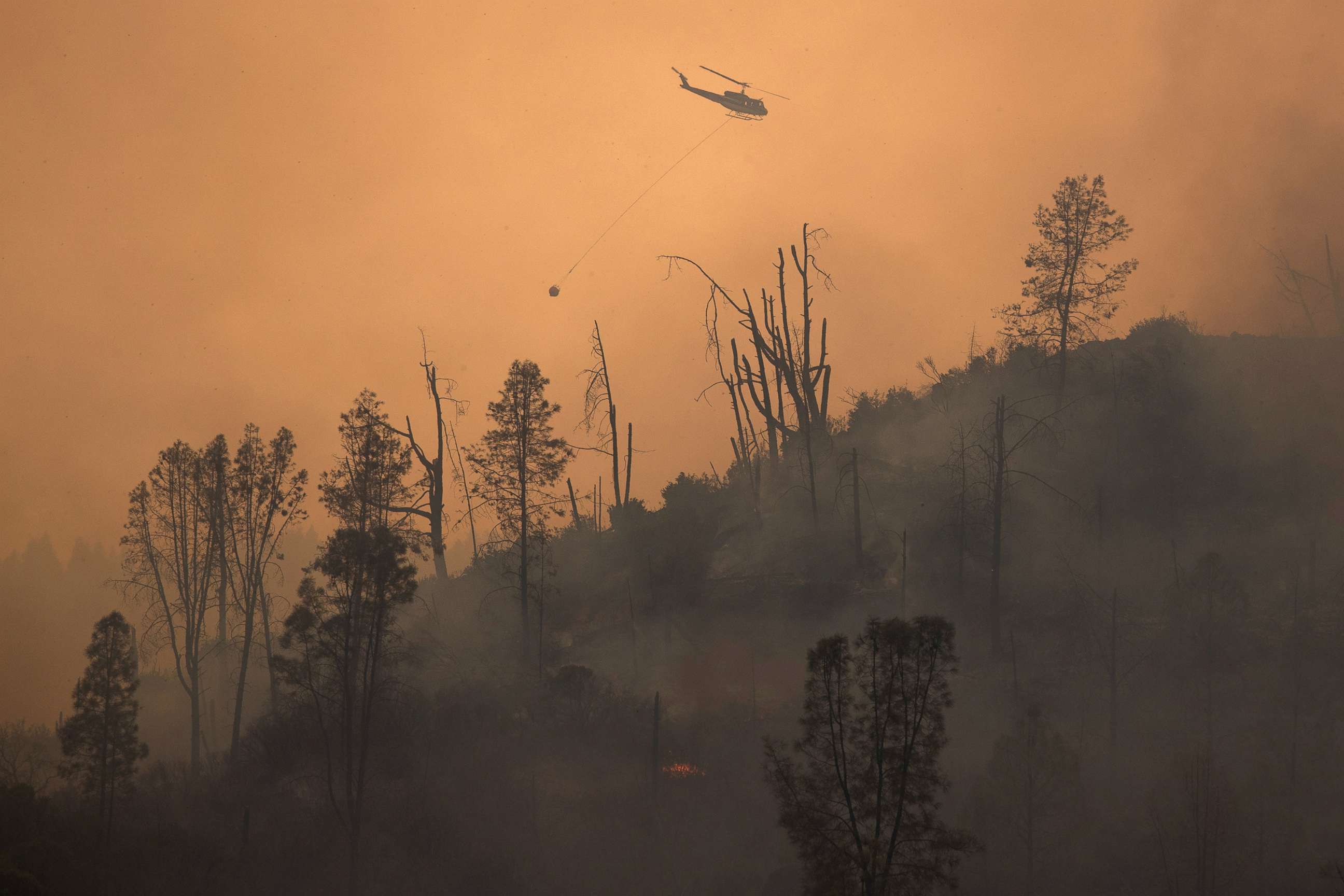 PHOTO: A helicopter and crew releases water to extinguish a section of the LNU Lightning Complex Fire near Middletown, Calif., Aug. 24, 2020.