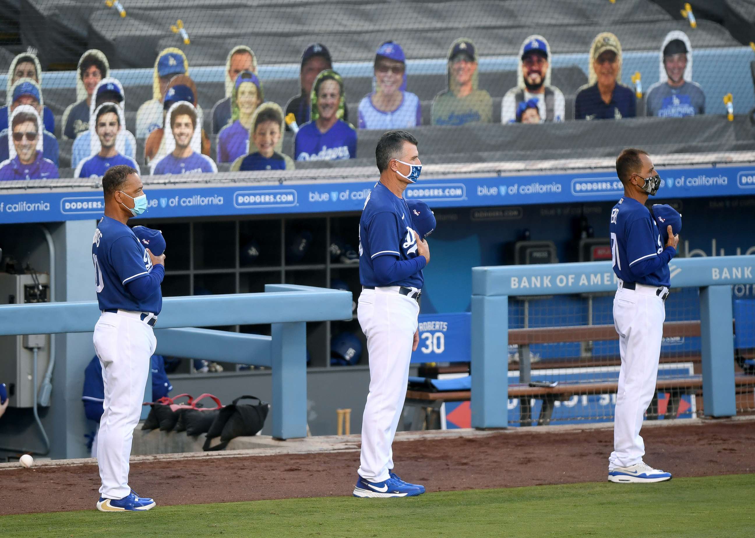 PHOTO: From left, manager Dave Roberts, Bob Geren, and Dino Ebel line up for the National Anthem for a preseason game against the Arizona Diamondbacks during the COVID-19 pandemic at Dodger Stadium on July 20, 2020, in Los Angeles.