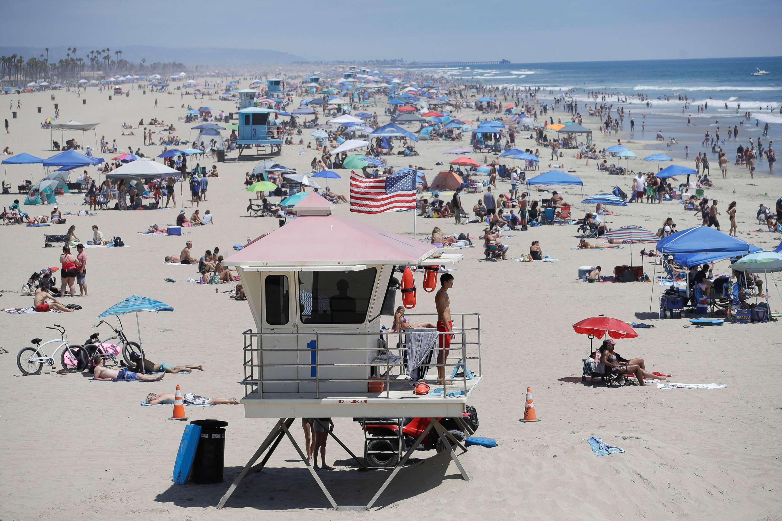 PHOTO: A lifeguard keeps watch over a packed beach in Huntington Beach, Calif., June 29, 2020.