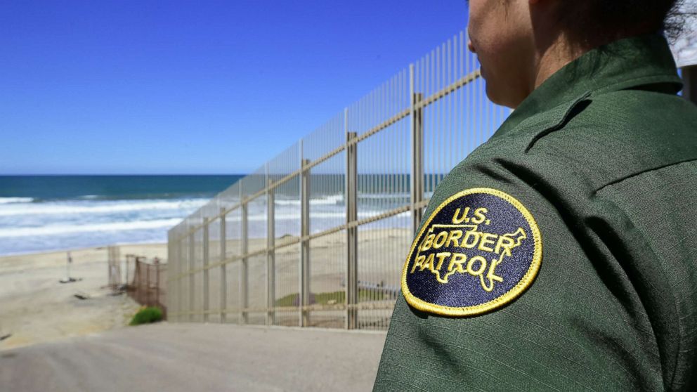 PHOTO: A US Customs and Border Protection agent looks from within the Border Infrastructure System, a no man's land which runs for 14 miles separating California from Mexico on April 17, 2018 in San Diego.