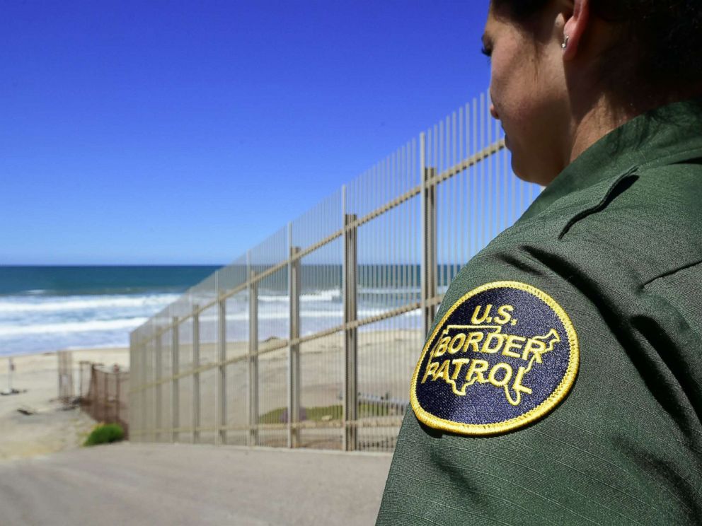 PHOTO: A US Customs and Border Protection agent looks from within the Border Infrastructure System, a no mans land which runs for 14 miles separating California from Mexico on April 17, 2018 in San Diego.