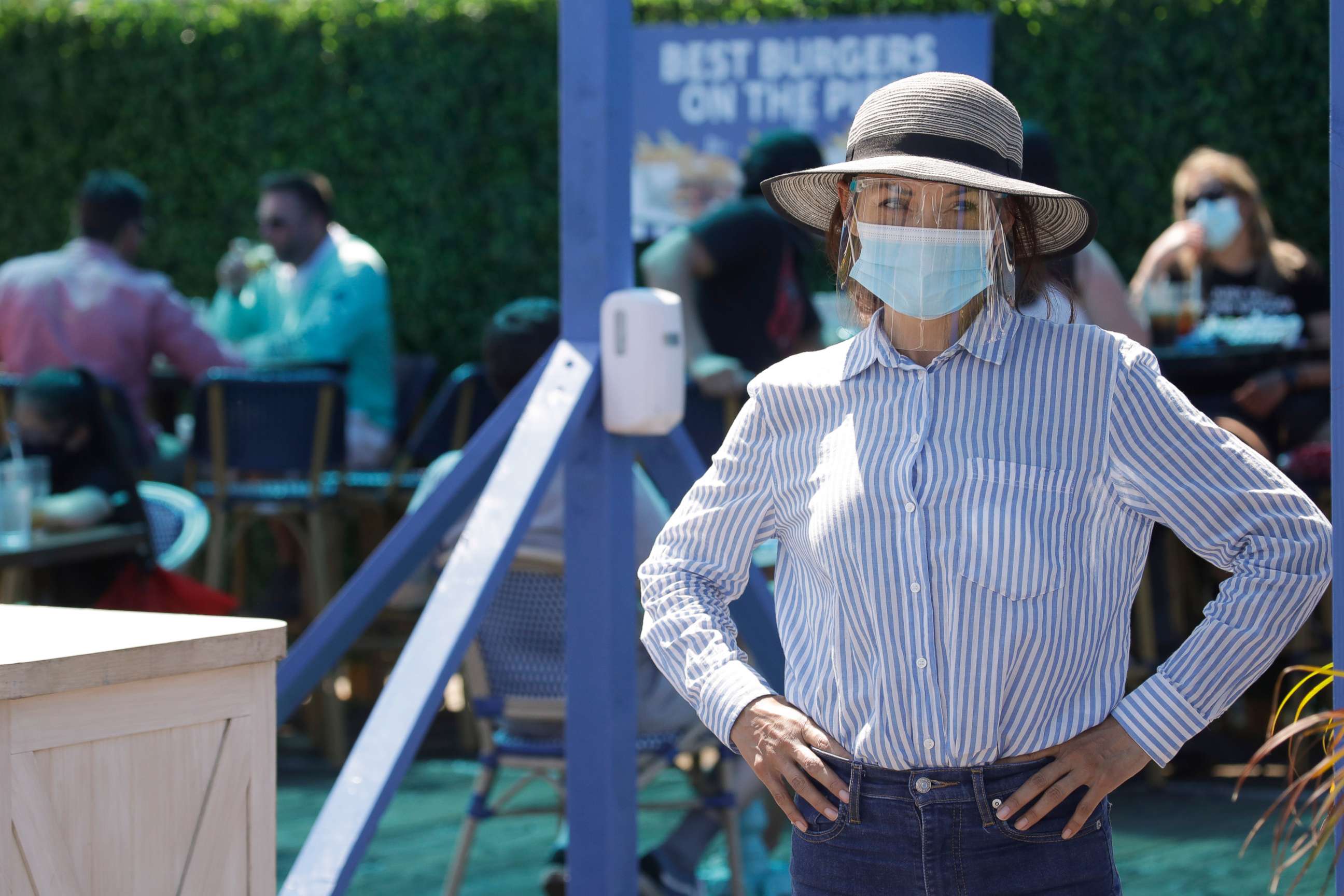 PHOTO: A hostess waits to sit customers at a restaurant on the pier, July 12, 2020, in Santa Monica, Calif., amid the coronavirus pandemic.
