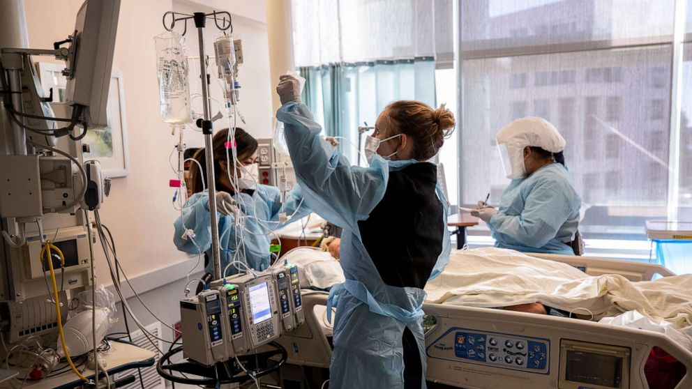 PHOTO: Nurses and caretakers treat a COVID-19 patient in the intensive care unit of the Sharp Grossmont Hospital in La Mesa, Calif., Jan. 11, 2022.