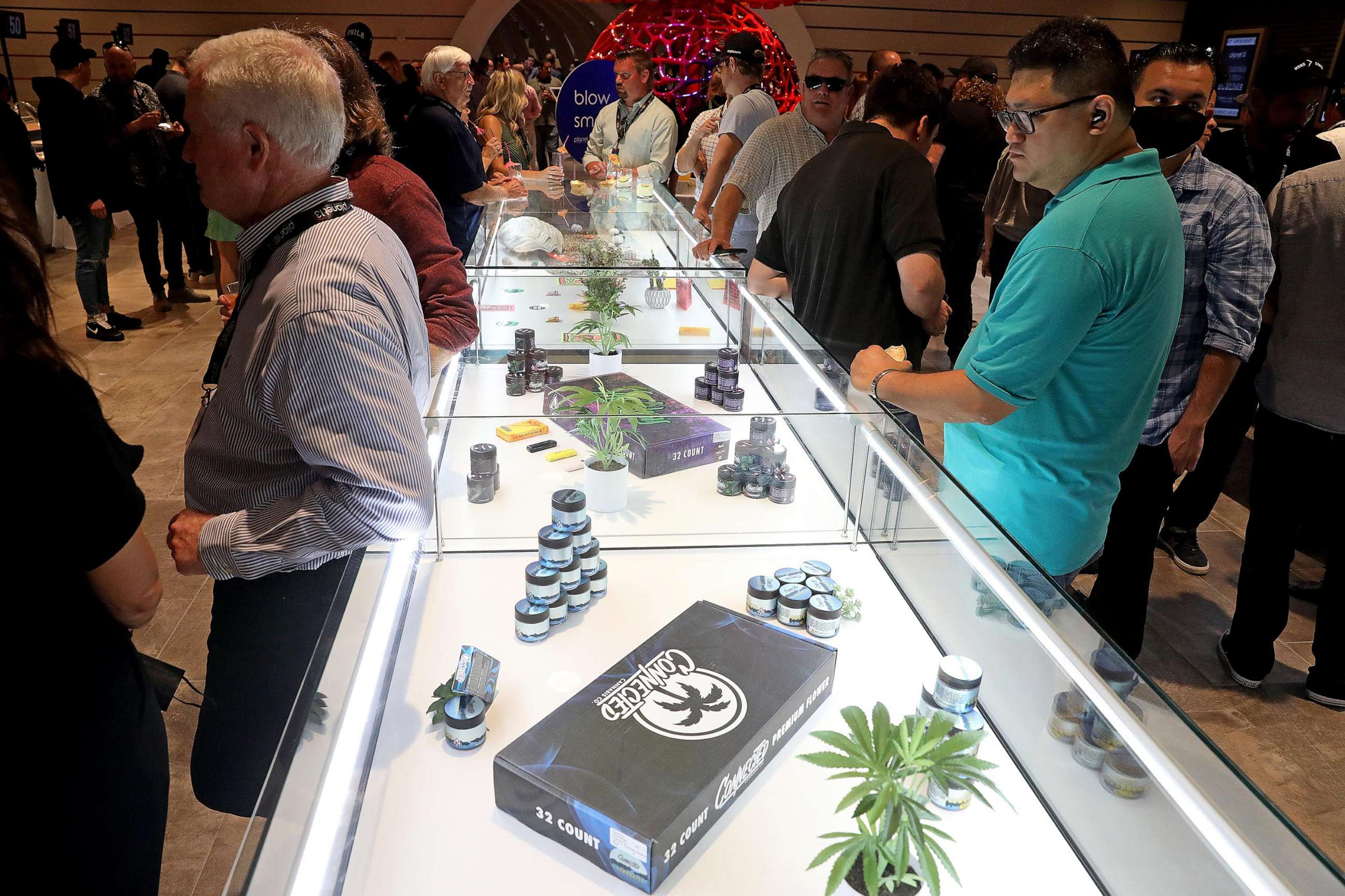 PHOTO: In this June 24, 2021, file photo, people check out a display case with merchandise at a VIP Event at Planet 13, in Santa Ana, Calif.