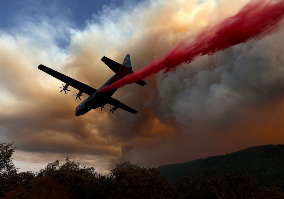 PHOTO: A Modular Airborne Fire Fighting Systems (MAFFS) equipped C-130 aircraft drops retardant ahead of the LNU Lightning Complex fire on Aug. 20, 2020, in Healdsburg, California.