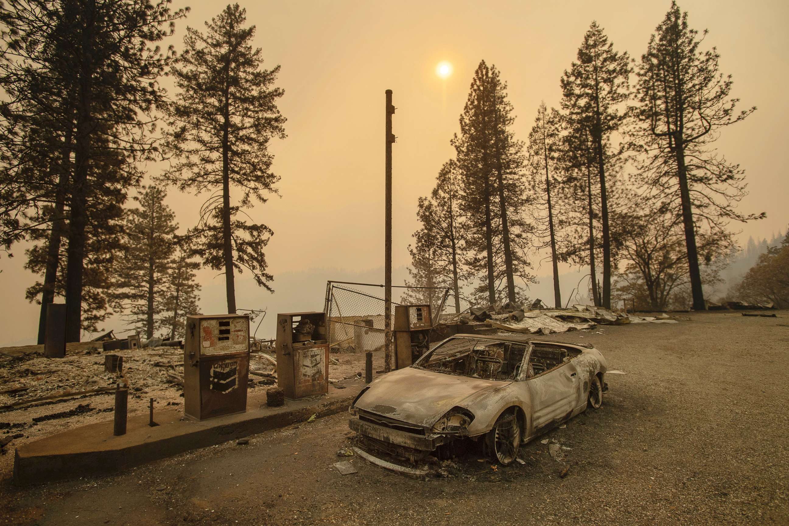 PHOTO: As the Camp Fire burns nearby, a scorched car rests by gas pumps near Pulga, Calif., Nov. 11, 2018.