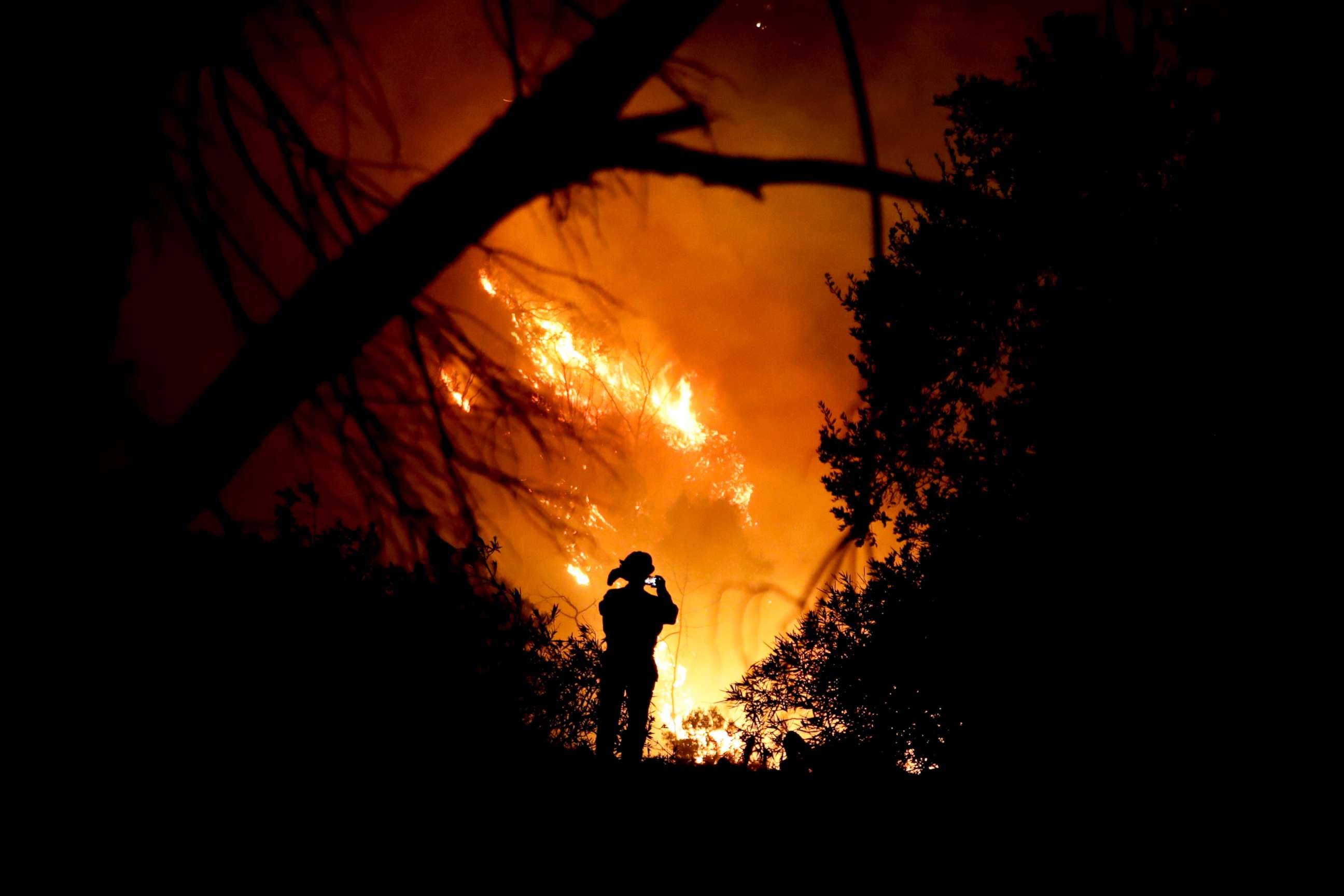 PHOTO: A firefighter takes a cell phone picture during a wildfire, Dec. 16, 2017, in Montecito, Calif. 