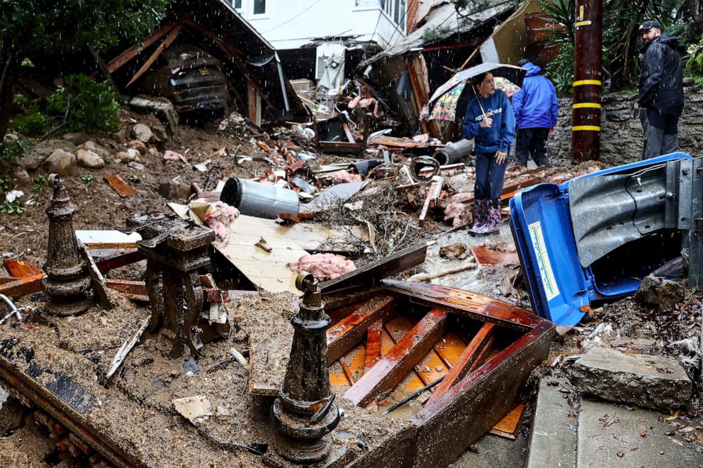 PHOTO: People gather where a home was destroyed by a mudslide as a powerful long-duration atmospheric river storm,  Feb. 5, 2024, in Los Angeles.
