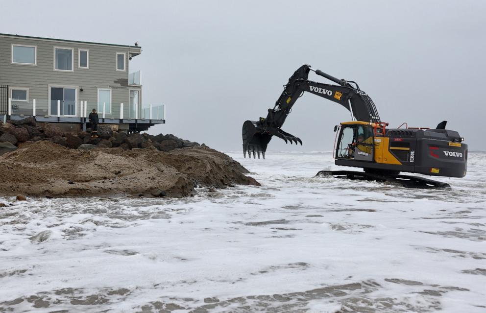 PHOTO: Workers shore up the Pacific Ocean coastline next to homes as a powerful atmospheric river storm continues to impact southern California, Feb. 5, 2024, near Malibu, Calif.