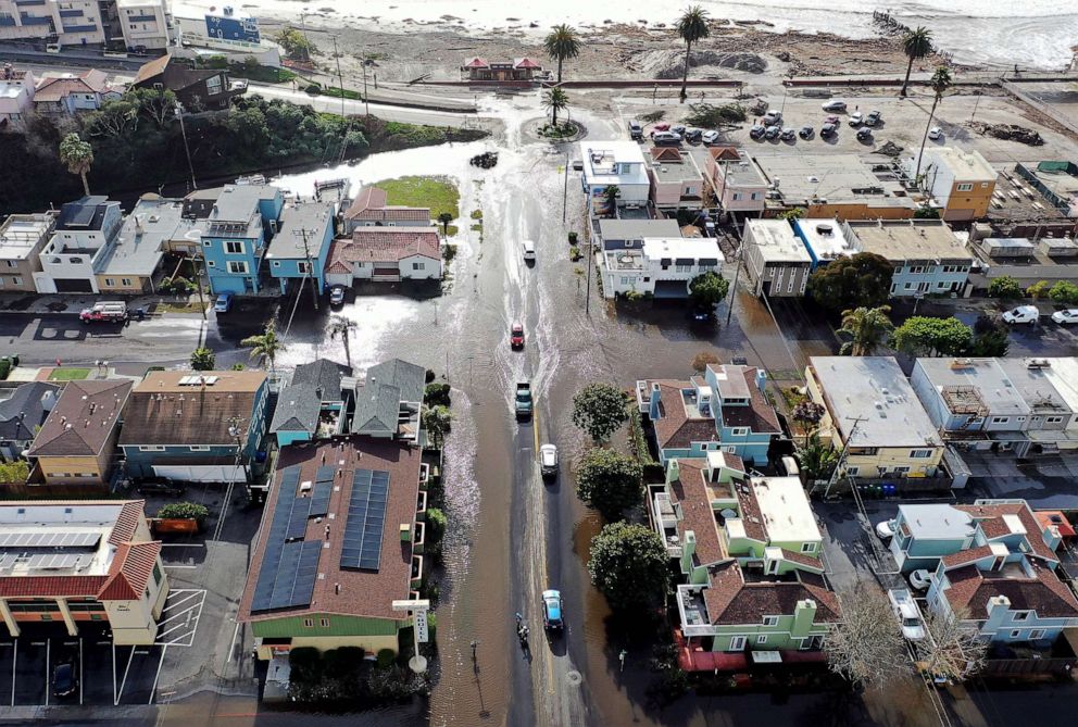 PHOTO: In an aerial view, vehicles drive along a flooded street close to the beach, Jan. 10, 2022 in Aptos, Calif.