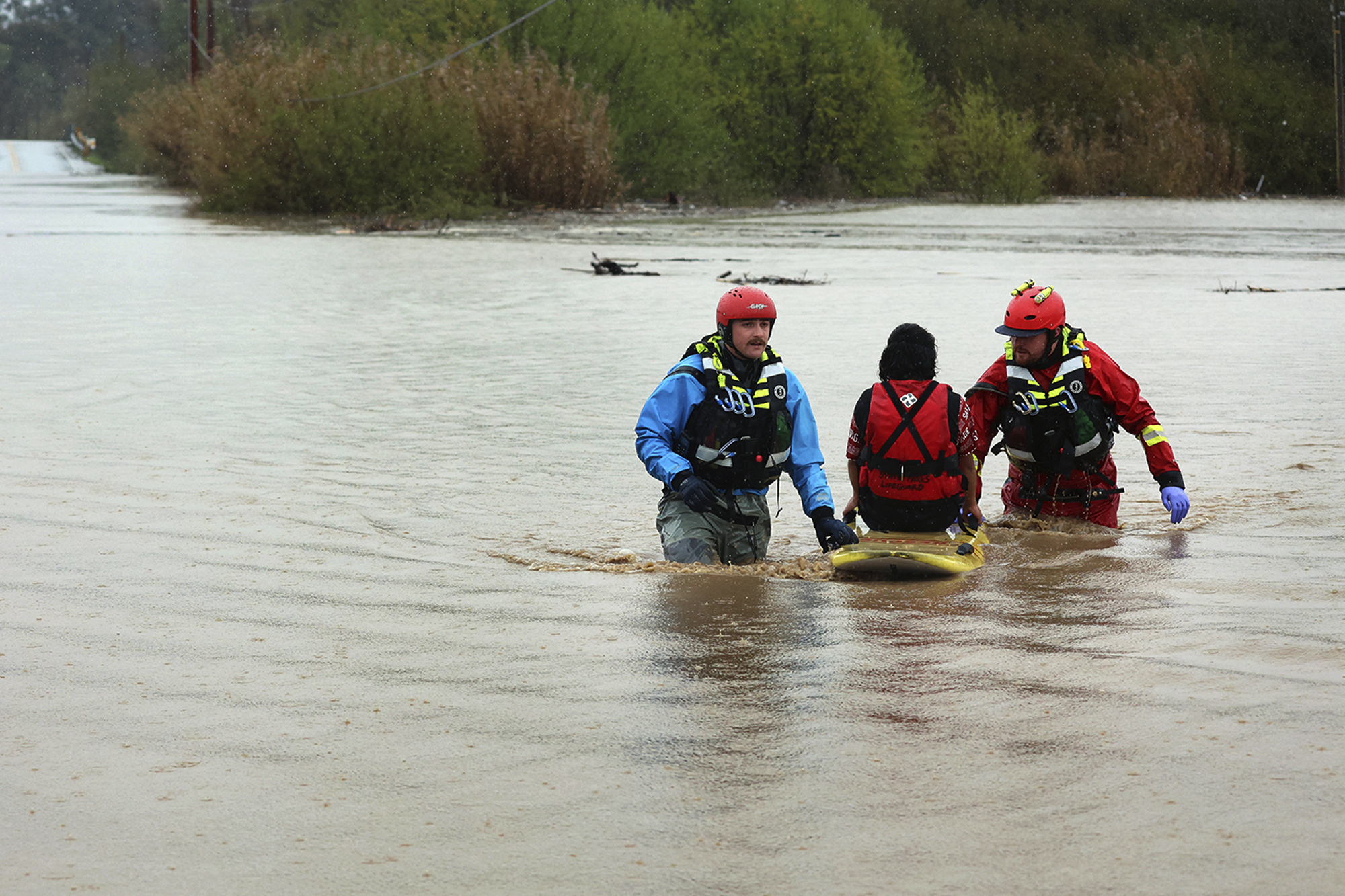 PHOTO: State Parks swift water technicians transport a woman to safety after her truck was swept away by flood waters along Paulsen Road in Watsonville, Calif., on March 10, 2023.