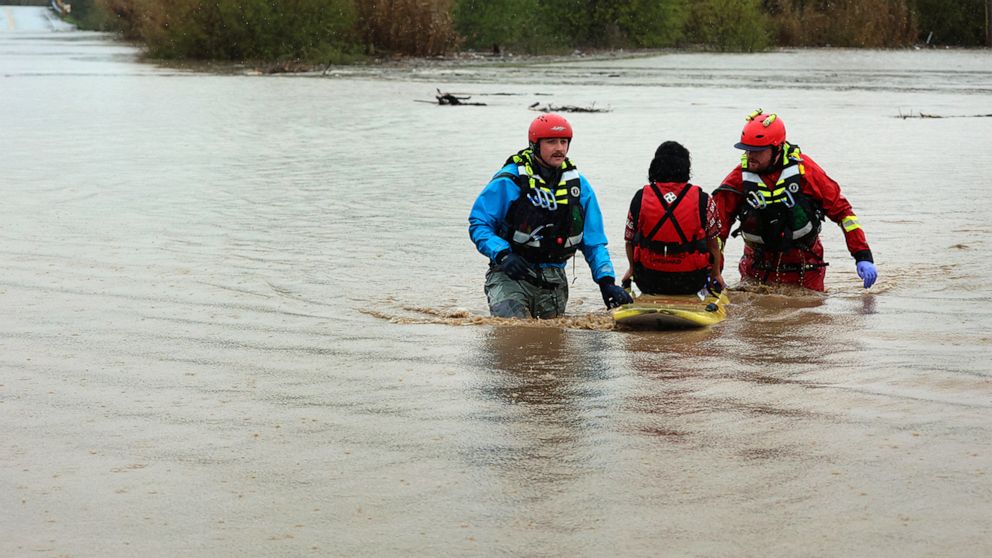 PHOTO: State Parks swift water technicians transport a woman to safety after her truck was swept away by flood waters along Paulsen Road in Watsonville, Calif., on March 10, 2023.