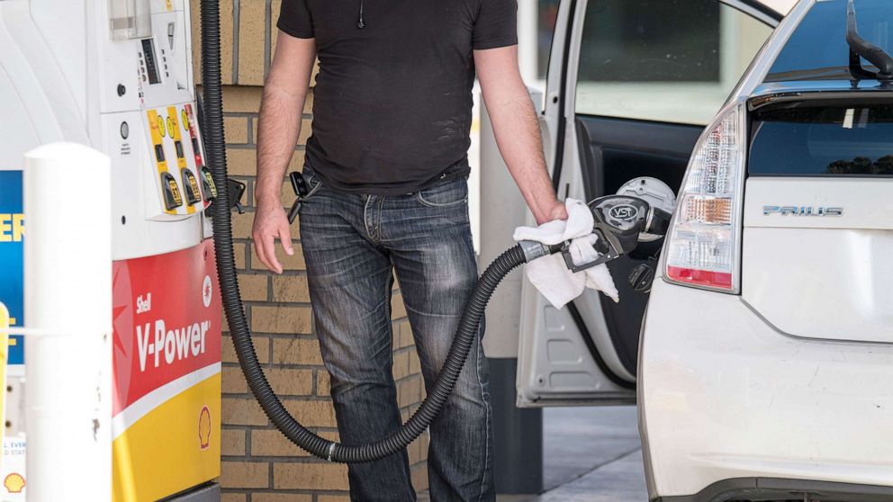 PHOTO: A person holds a fuel pump nozzle while refueling at a Royal Dutch Shell Plc gas station in Colma, Calif., Sept. 24, 2020.