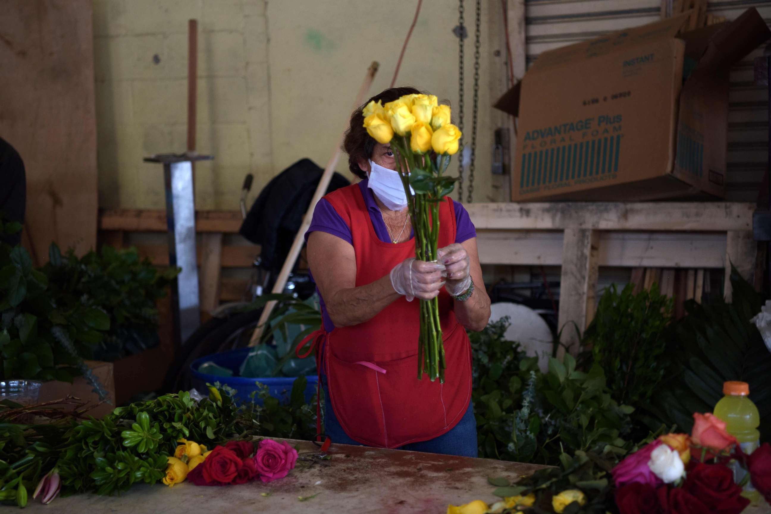 PHOTO: A woman prepares a flower bouquetat a shop in the Los Angeles Flower District, May 8, 2020, after the county allowed retail establishments to open ahead of Mother's Day.