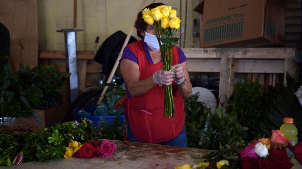 PHOTO: A woman prepares a flower bouquetat a shop in the Los Angeles Flower District, May 8, 2020, after the county allowed retail establishments to open ahead of Mother's Day.