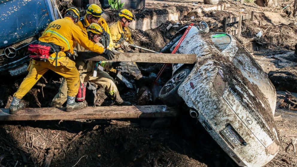 Rescue workers search in an around cars for missing persons after a mudslide in Montecito, Calif., Jan. 12, 2018.