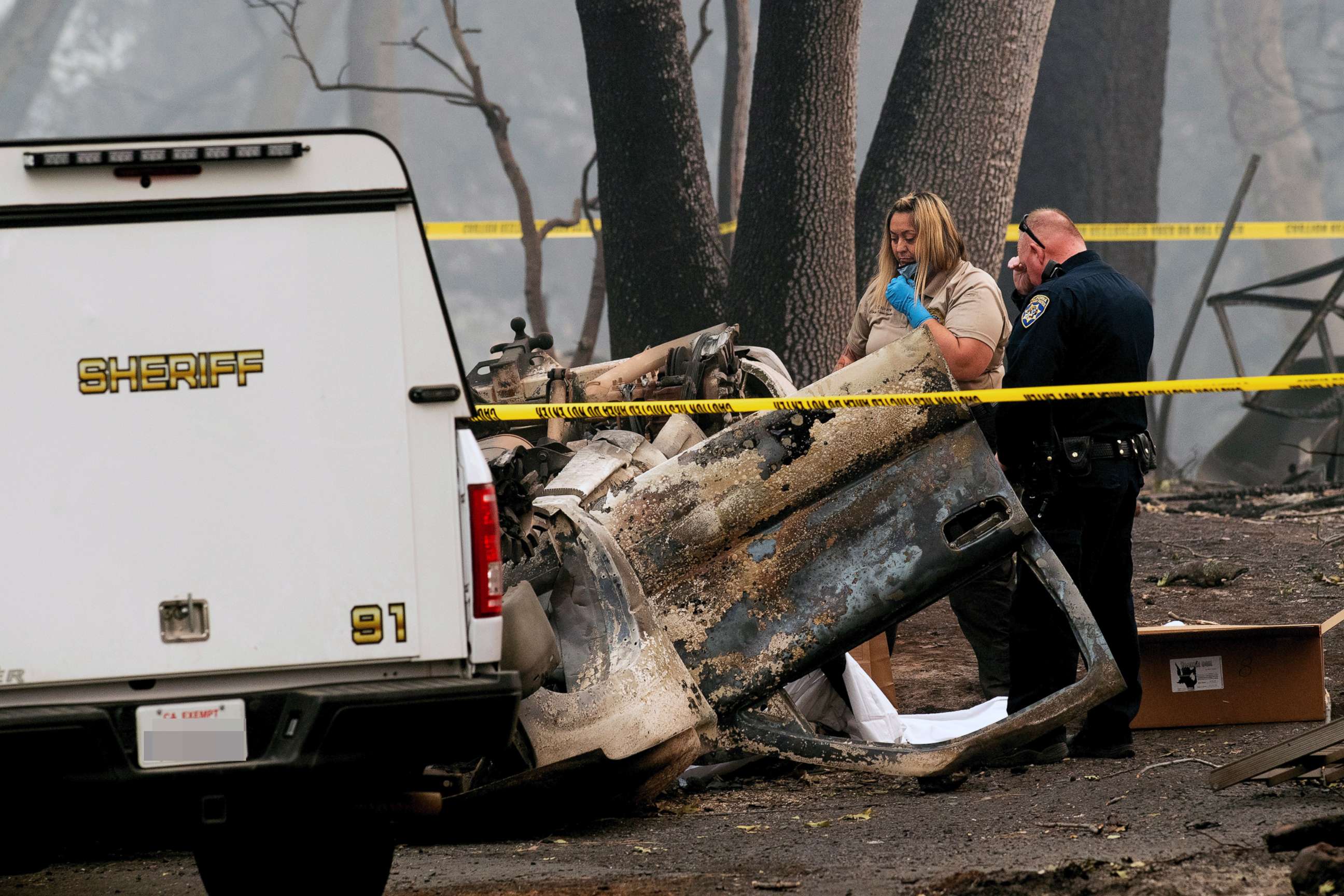 PHOTO: A sheriff's deputy recovers the remains of a Camp Fire victim from an overturned car in Paradise, Calif., Nov. 15, 2018.