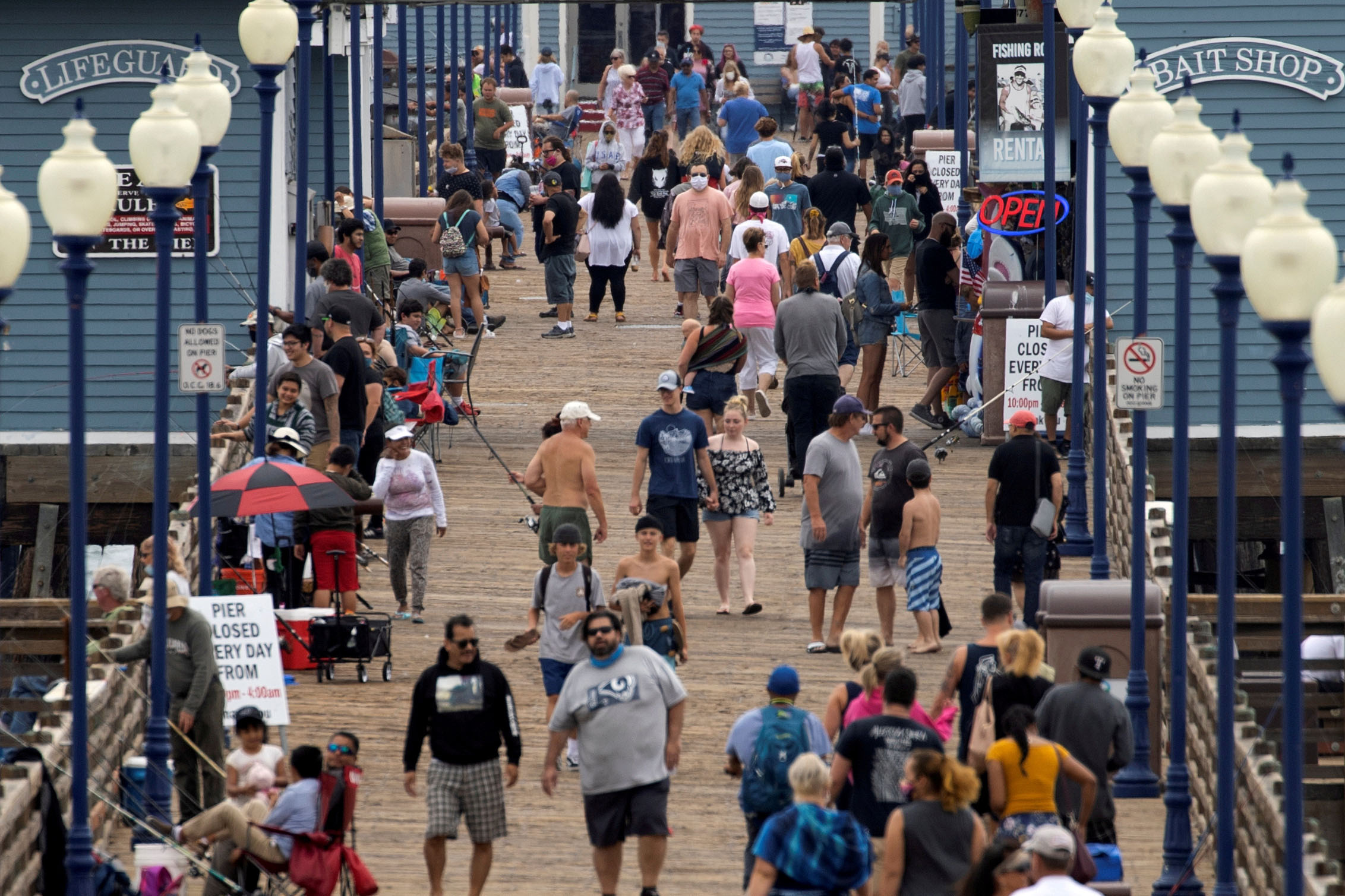 PHOTO: Few people wear masks as they walk on the beach pier in Oceanside, Calif., June 22, 2020.
