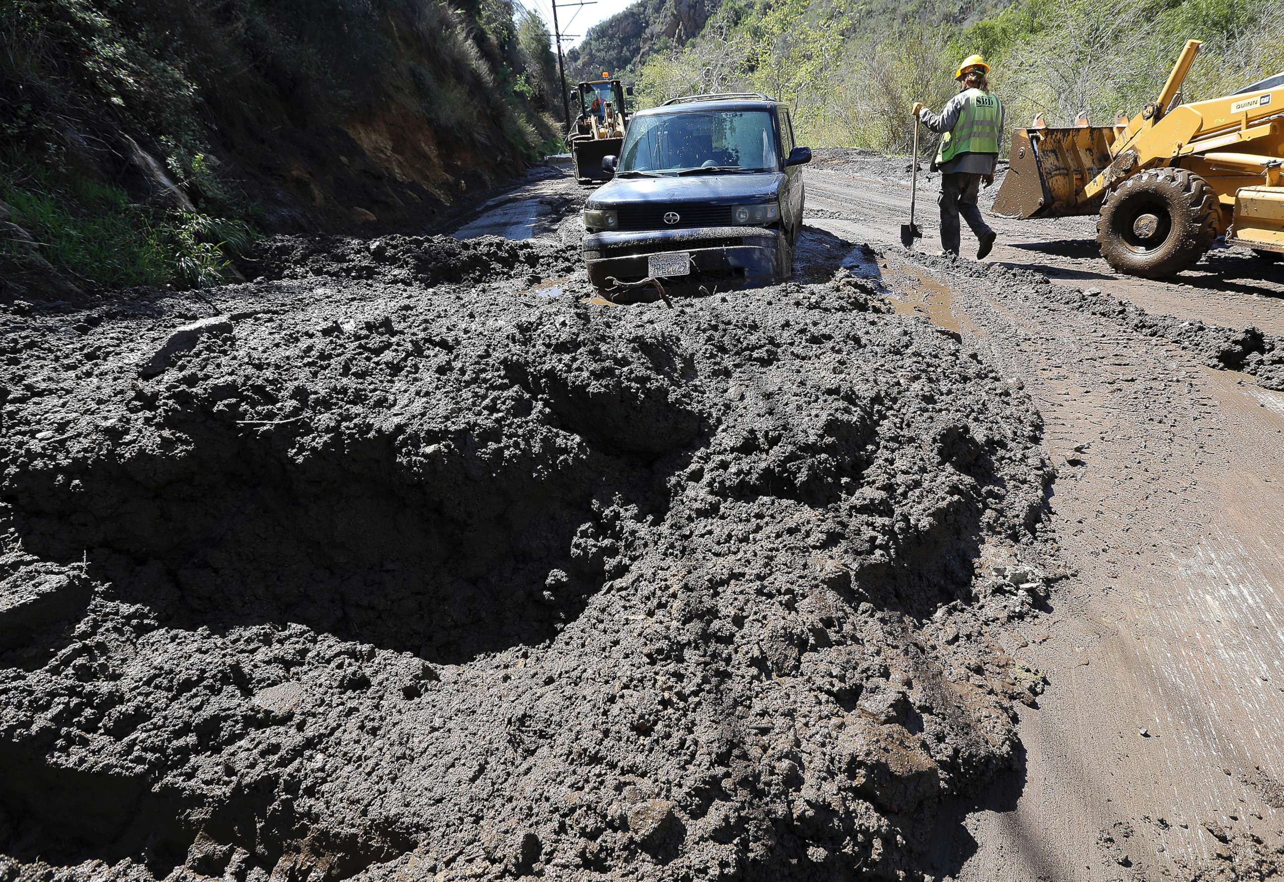 PHOTO: Workers prepare to free a trapped car from tons of debris after mudslides from heavy rain overnight caused the closure of Topanga Canyon Boulevard in Malibu, Calif., March 15, 2018.