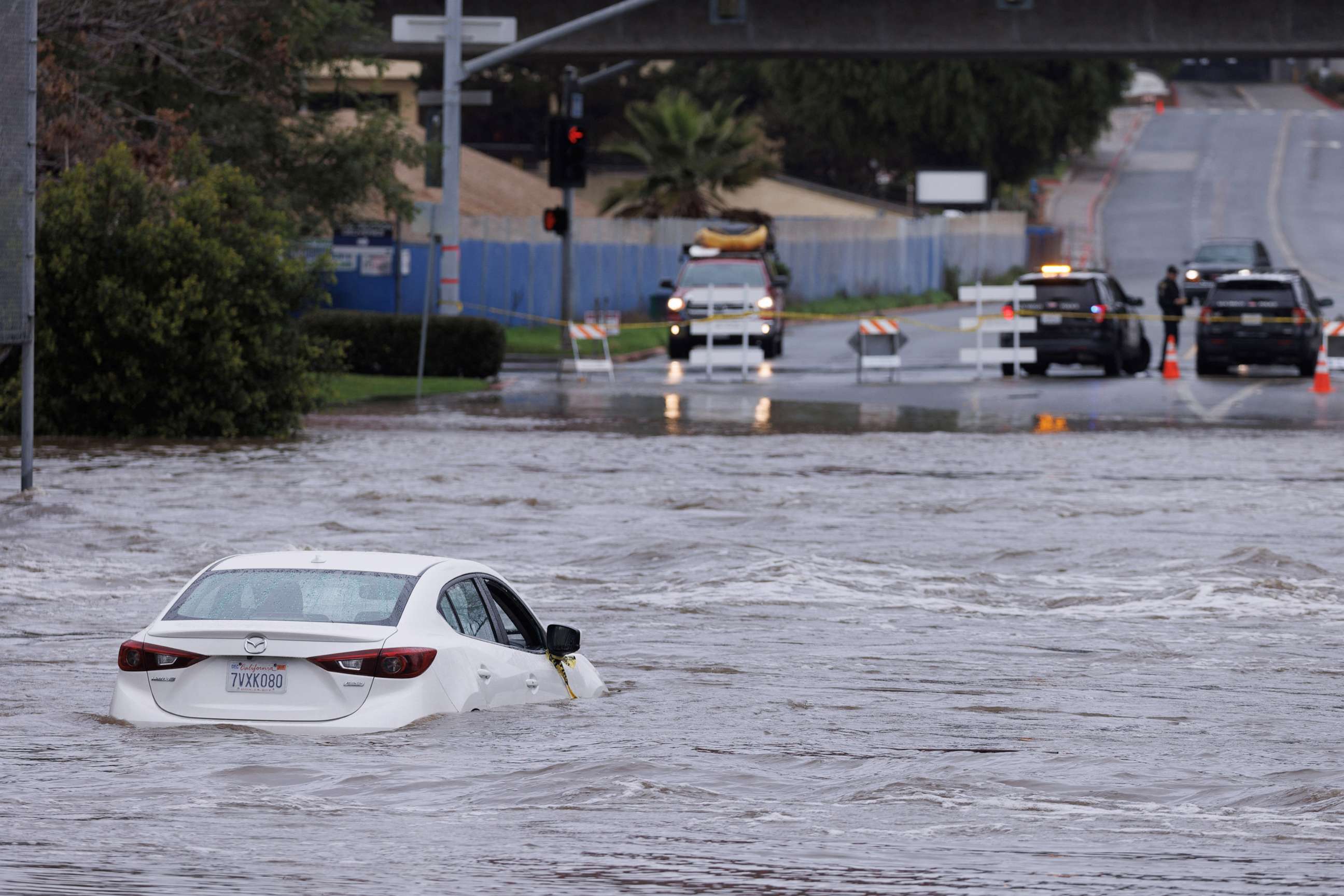 PHOTO: An abandoned car sits trapped on the street in overflow water from the San Diego River in San Diego, Calif., on Jan. 16, 2023.
