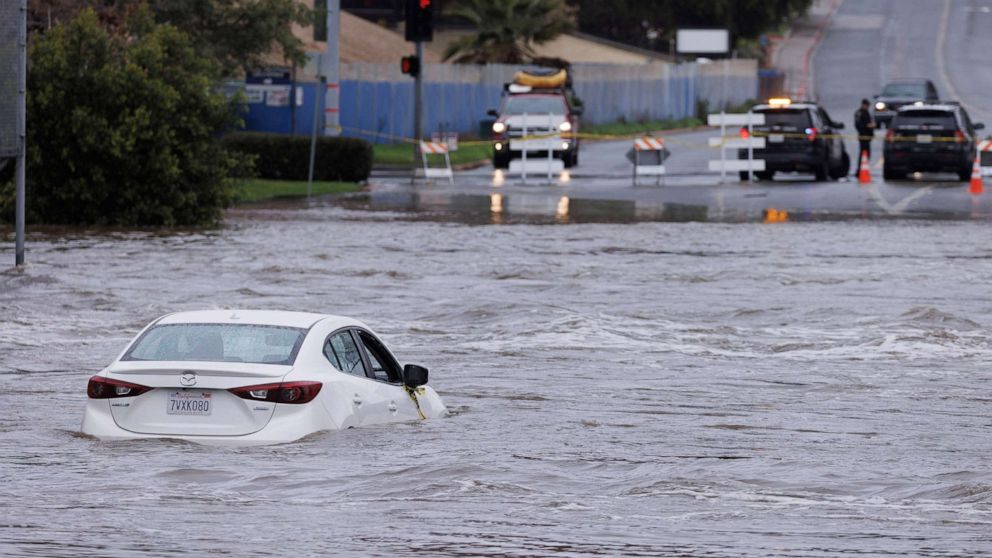 PHOTO: An abandoned car sits trapped on the street in overflow water from the San Diego River in San Diego, Calif., on Jan. 16, 2023.