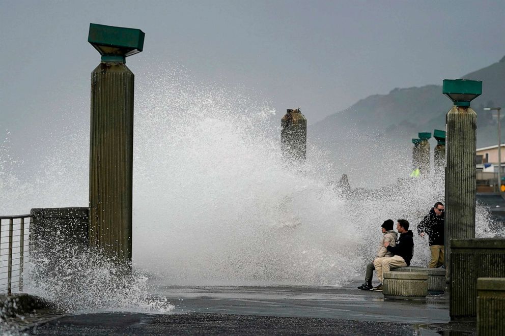PHOTO: People watch as waves crash into a seawall in Pacifica, Calif., Jan. 6, 2023.
