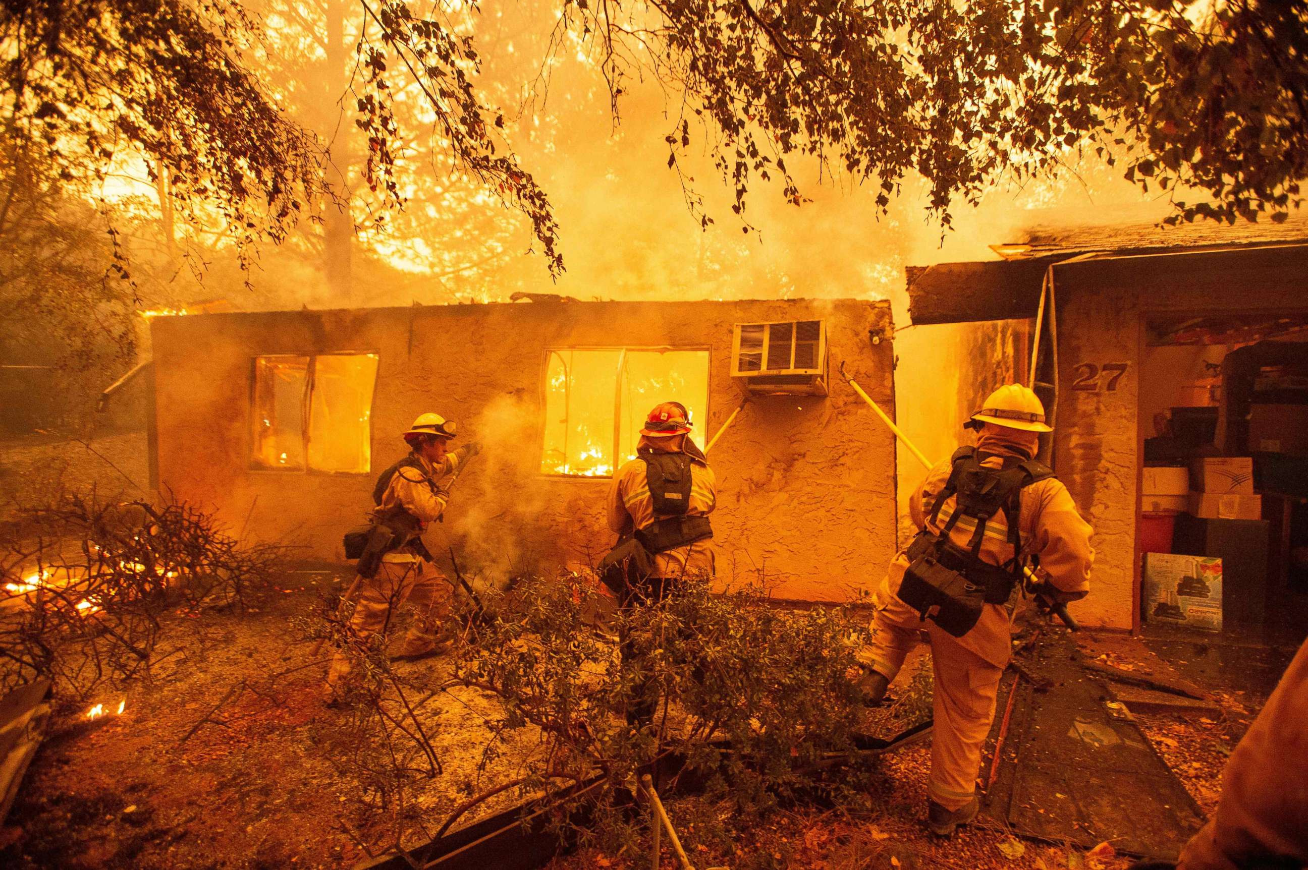 PHOTO: Firefighters push down a wall while battling a fire in an apartment complex in Paradise, Calif., Nov. 09, 2018.