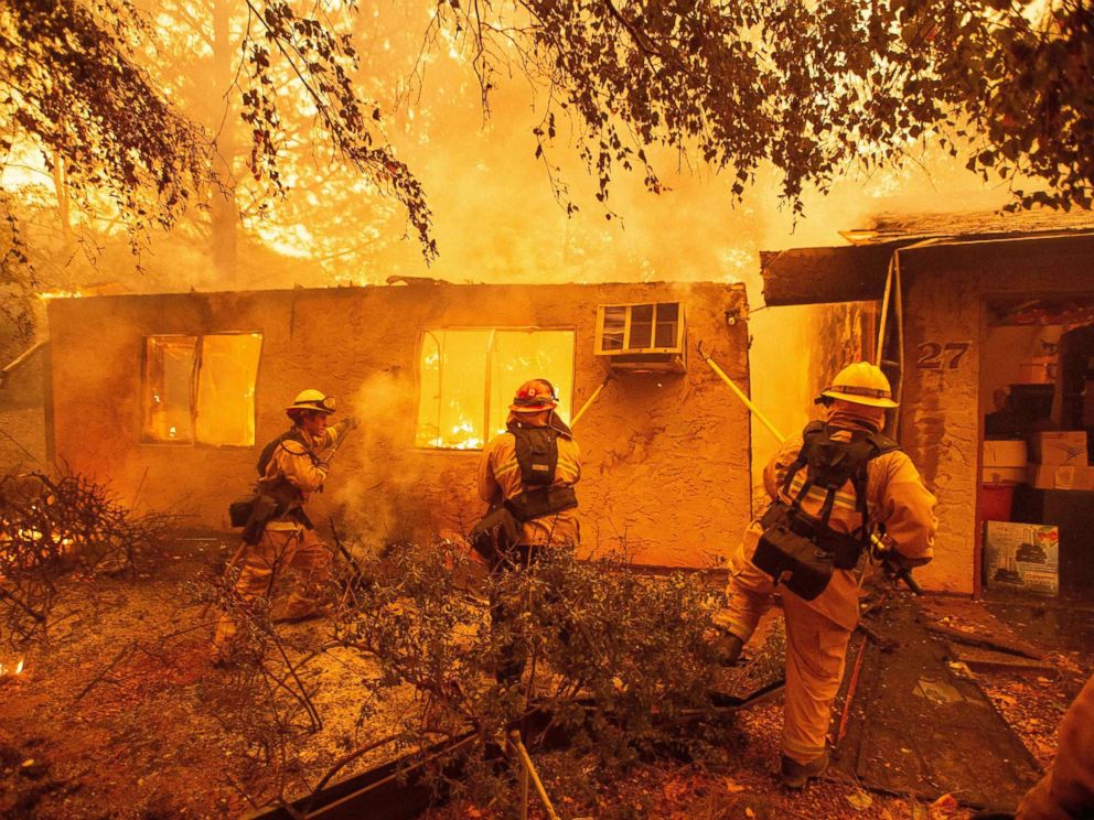 PHOTO: Firefighters push down a wall while battling a fire in an apartment complex in Paradise, Calif., Nov. 09, 2018.