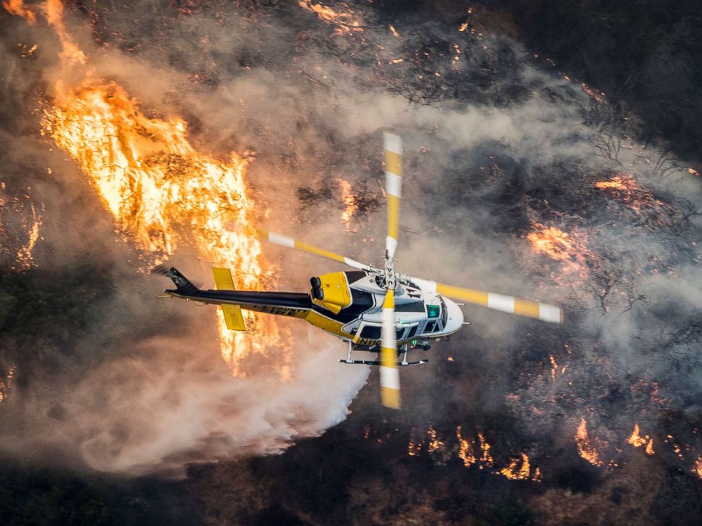 PHOTO: A Los Angeles County Fire helicopter flies over the Skirball Fire which began early morning in Bel-Air, Calif., Dec. 6, 2017.