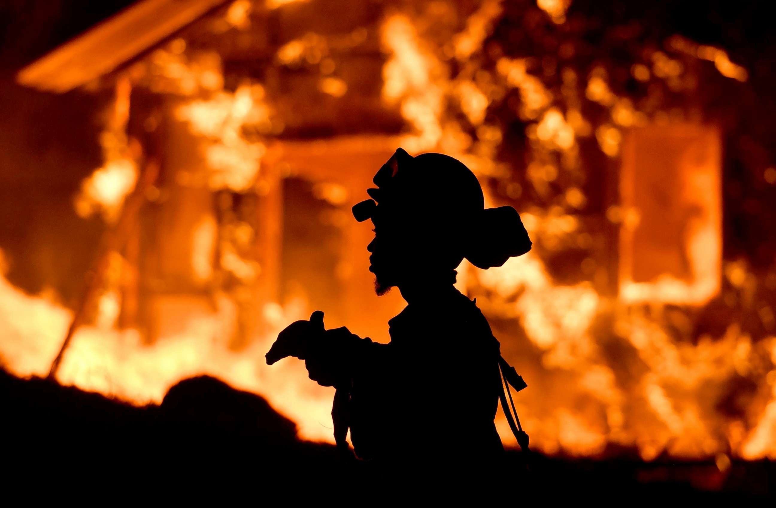 PHOTO: A firefighter monitors flames as a house burns in the Napa wine region in California, Oct. 9, 2017, as multiple wind-driven fires continue to whip through the region. 